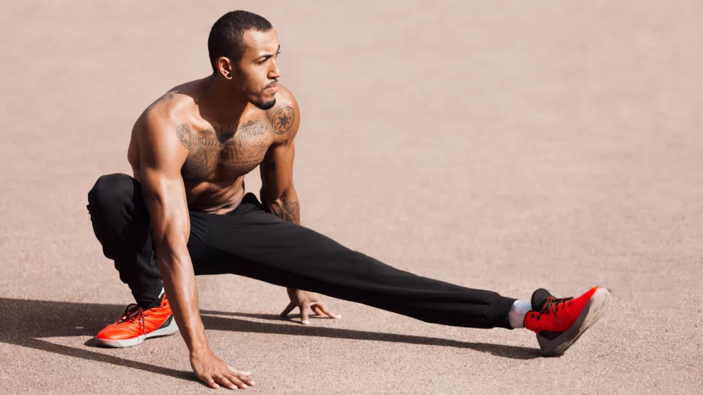 Fit shirtless black man doing stretching before workout - NinjaFitness Man Stretching