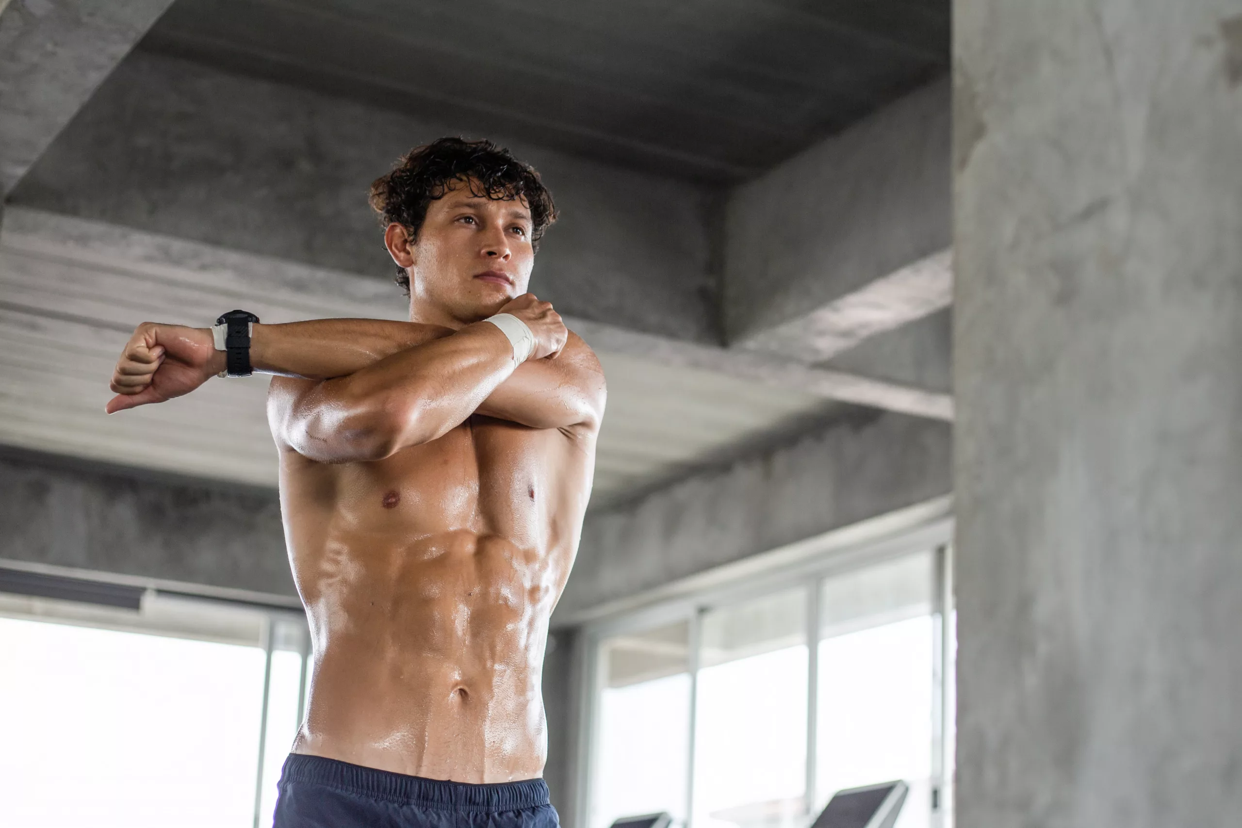 Topless young man warm up exercise before workout at gym
