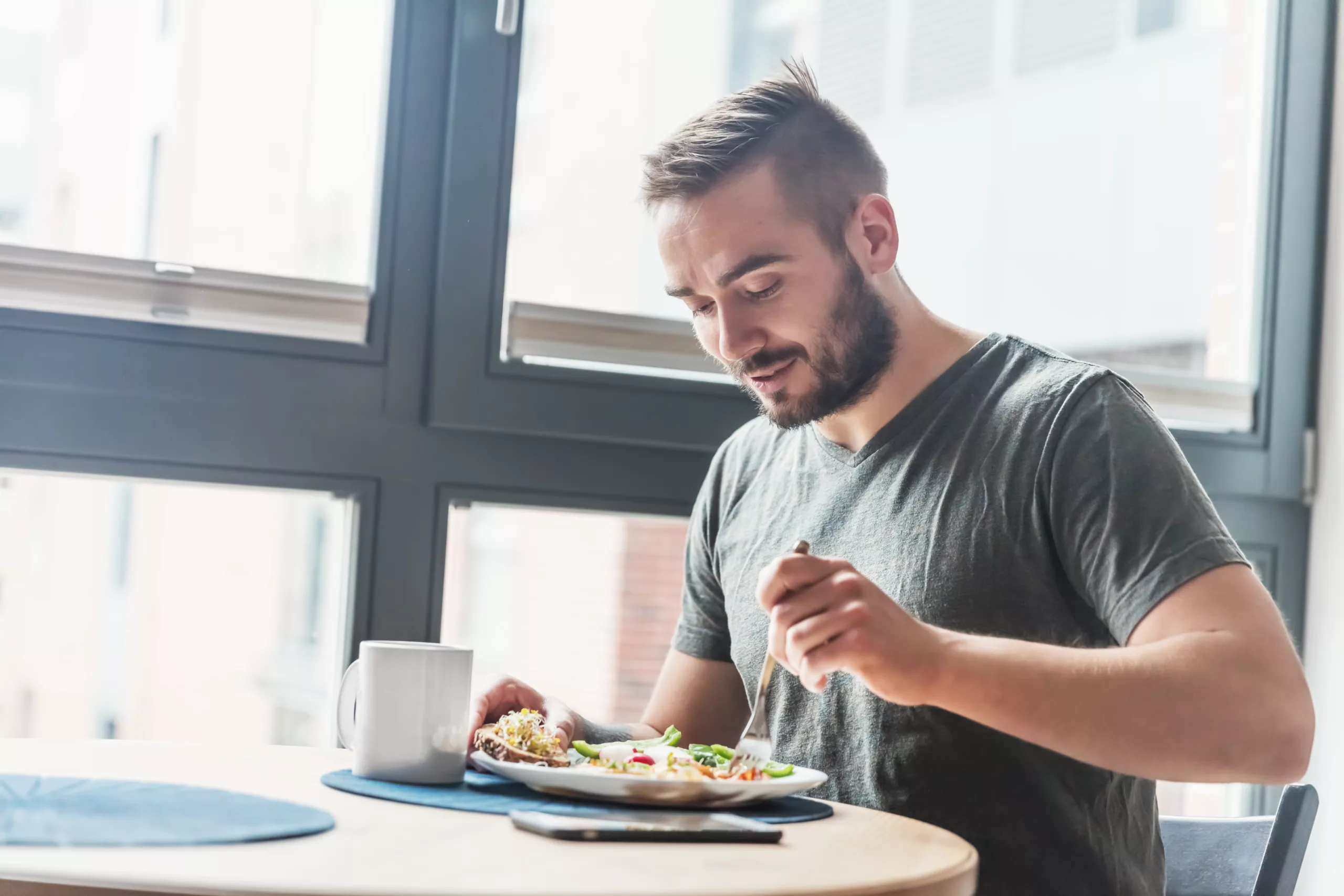 Man eating a healthy breakfast - NinjaFitness A man eating a healthy morning meal, breakfast at home. Fit lifestyle.
