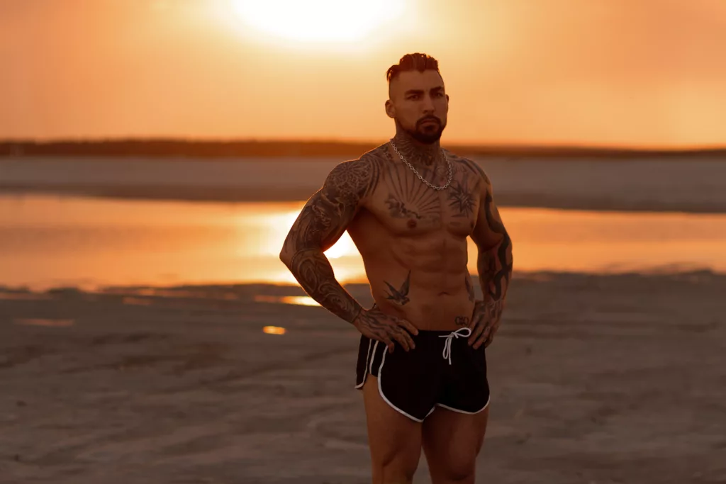 Handsome young muscular man posing shirtless on the beach, sunset summer time. Ideal fit body.